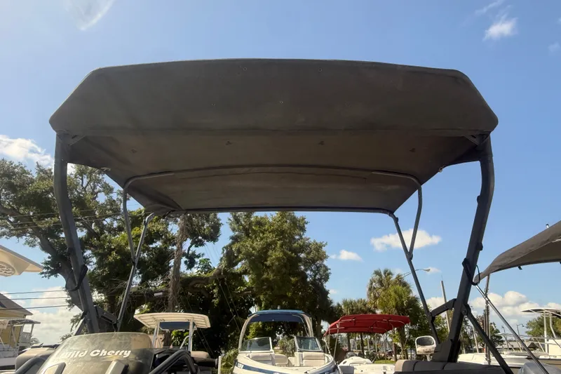 Slide: The Image of 2023 Sea-Doo Switch Cruise 21 with canopy, parked outdoors under a clear blue sky. - 7
