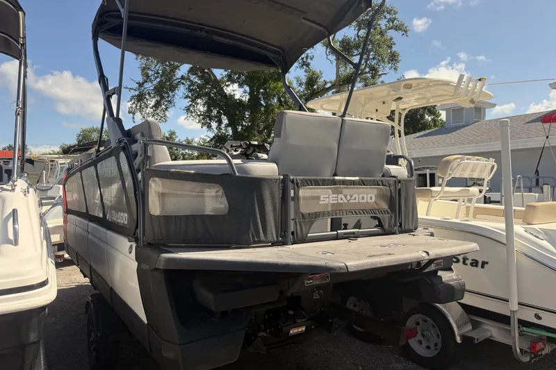 Slide: The Image of 2023 Sea-Doo Switch Cruise 21 pontoon boat parked at a marina under clear skies. - 4