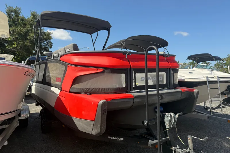 The Image of 2023 Sea-Doo Switch Cruise 21 pontoon boat in a parking lot, rear view. - 0