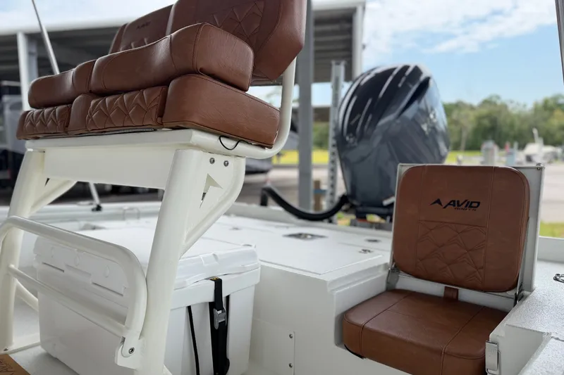 Slide: The Image of 2027 Avid 21 Fusion boat interior with brown leather seating and visible outboard motor. - 15