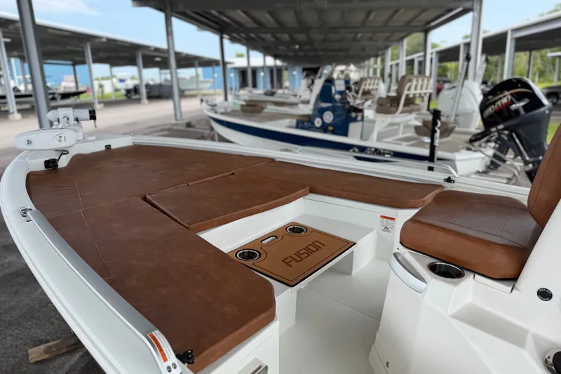 Slide: The Image of Avid 21 Fusion 2027 boat with brown seating, docked under a covered marina. - 20