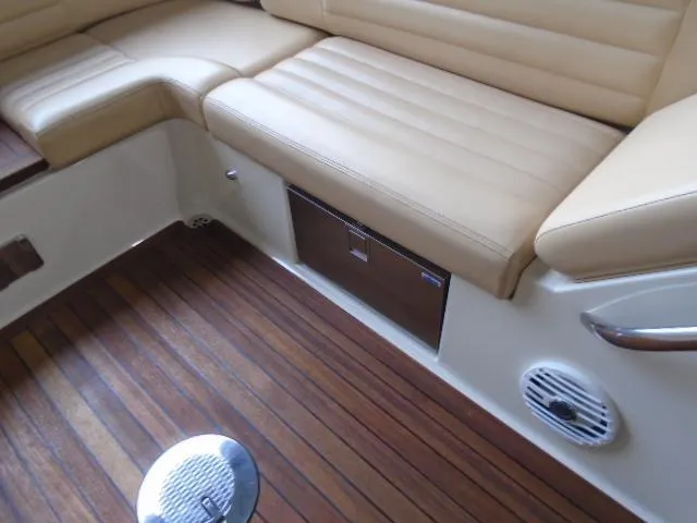 Slide: The Image of The image shows the cockpit of a 2012 Chris-Craft Corsair 28 with beige leather seats and wooden flooring. - 13