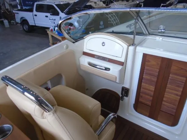 Slide: The Image of Interior of a 2012 Chris-Craft Corsair 28 with beige seating and wood paneling. - 8