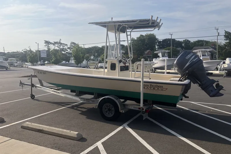 Slide: The Image of 2005 Jones Brothers Bateau 19 boat on trailer in parking lot with Yamaha outboard motor. - 2