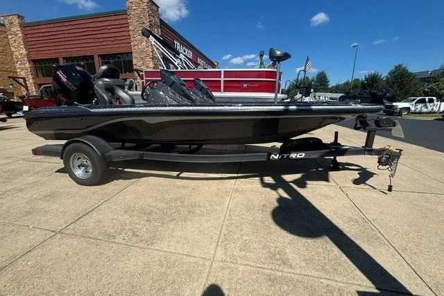 The Image of 2023 Nitro Z18 boat on trailer, parked outdoors under clear blue sky. - 0