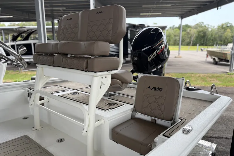 Slide: The Image of 2027 Avid 21 FSX boat interior with cushioned seating and Yamaha outboard motor. - 13