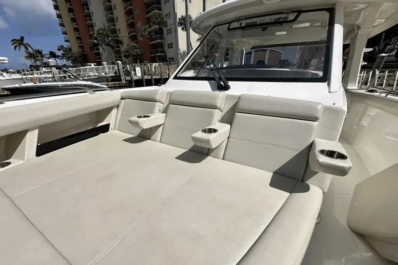 Slide: The Image of 2019 Boston Whaler 350 Realm boat interior with beige seating and cup holders. - 18