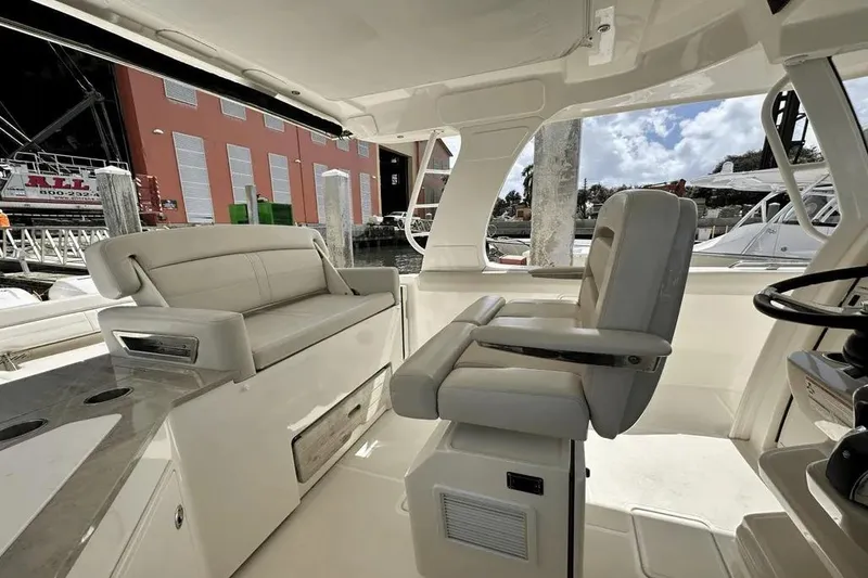 Slide: The Image of 2019 Boston Whaler 350 Realm interior with plush seating and helm station. - 17