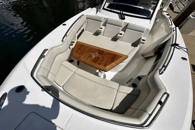 Slide: The Image of 2019 Boston Whaler 350 Realm boat with luxurious seating and wooden table. - 16