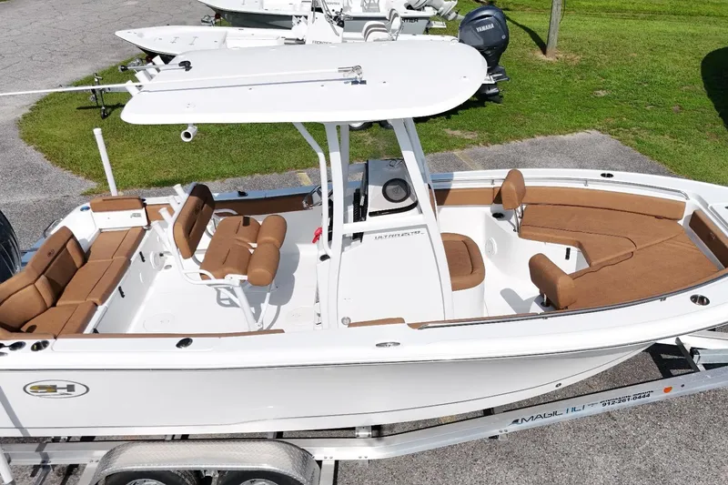 The Image of 2022 Sea Hunt Ultra 229 boat with brown seating and white hull on a trailer. - 1