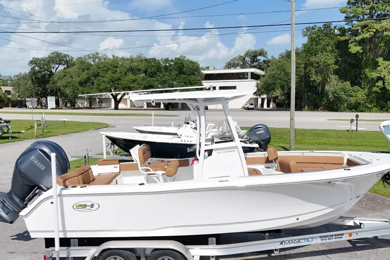 Slide: The Image of 2022 Sea Hunt Ultra 229 boat on trailer, featuring Yamaha engine, parked outdoors. - 15
