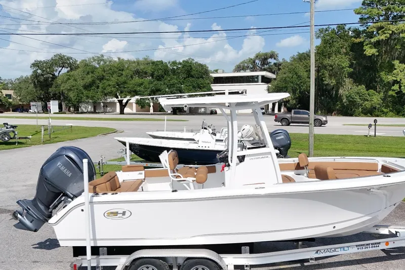 Slide: The Image of 2022 Sea Hunt Ultra 229 boat on trailer, featuring Yamaha engine, parked outdoors. - 16