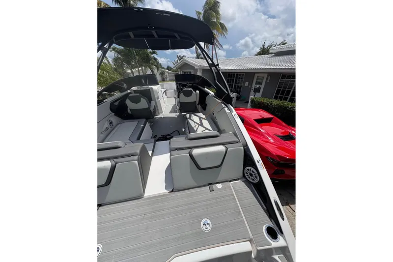 Slide: The Image of 2024 Yamaha Boats AR250 interior with sleek design, parked near a red sports car. - 3