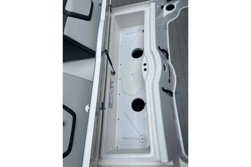 Slide: The Image of 2024 Yamaha AR250 boat storage compartment with cup holders and sleek design. - 17