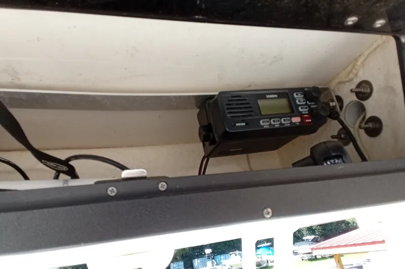 Slide: The Image of 2016 Key West 210 Bay Reef boat radio equipment in storage compartment. - 18