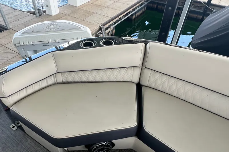 Slide: The Image of 2023 Harris Crowne SL 250 boat interior with beige seating and cup holders. - 16