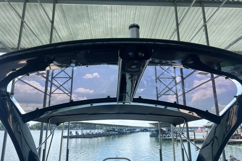 Slide: The Image of 2023 Harris Crowne SL 250 boat under a dock, showcasing sleek design and water view. - 27