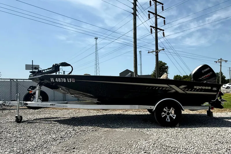 The Image of 2024 Xpress H18 Bass boat on trailer, parked outdoors under clear sky. - 1