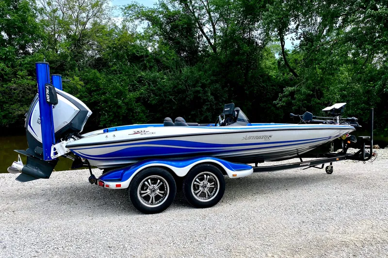 The Image of A 2016 Stratos 201 XL Evolution boat on a trailer, surrounded by trees. - 1