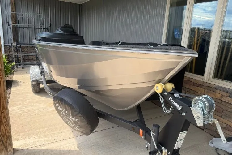 Slide: The Image of 2026 Crestliner 1650 Kodiak SC boat on trailer, parked outside a building. - 3