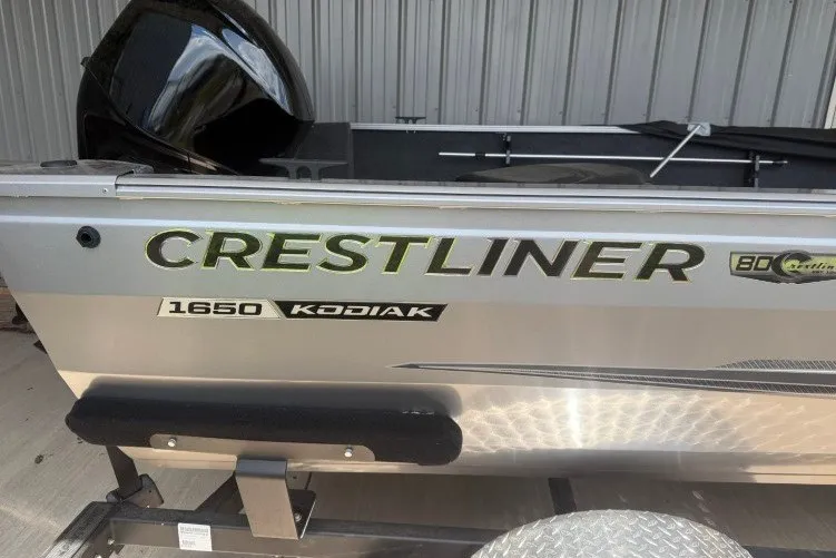 Slide: The Image of 2026 Crestliner 1650 Kodiak SC boat side view with branding and logo. - 2