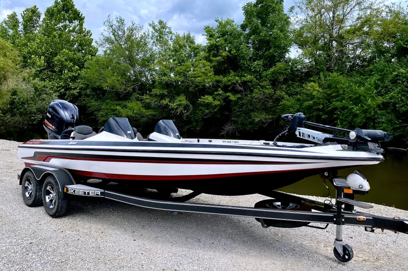 The Image of 2017 Skeeter ZX250 on a trailer, surrounded by trees, featuring two outboard motors. - 1