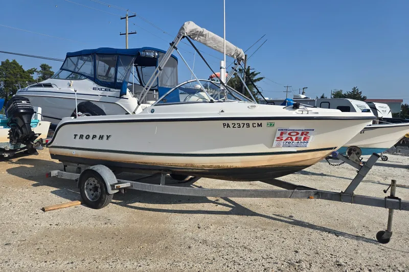 Slide: The Image of 2001 Bayliner 1700 Trophy Dual Console boat for sale on trailer in a marina. - 6