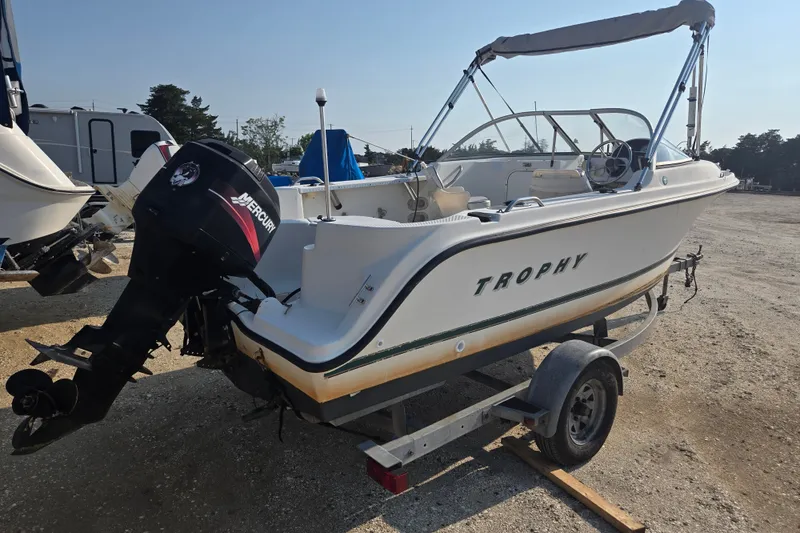 Slide: The Image of 2001 Bayliner 1700 Trophy Dual Console boat on trailer with Mercury outboard motor. - 0