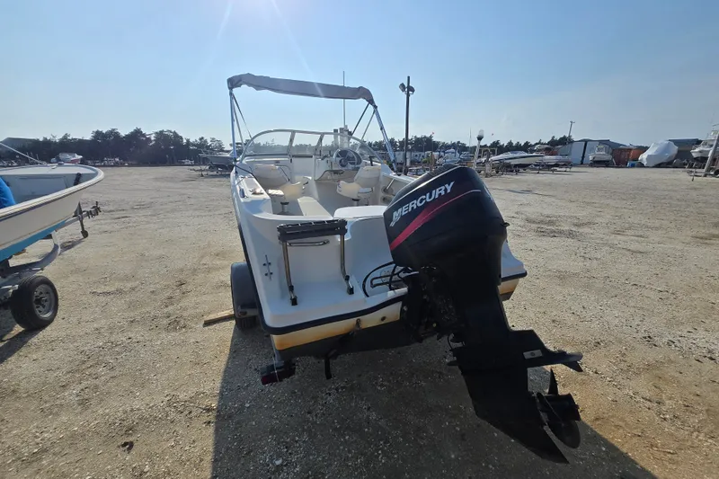 Slide: The Image of 2001 Bayliner 1700 Trophy Dual Console boat with Mercury outboard motor on a trailer. - 2