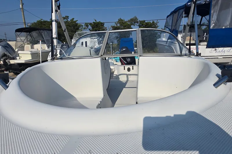 Slide: The Image of 2001 Bayliner 1700 Trophy Dual Console boat with open bow seating, docked outdoors. - 8