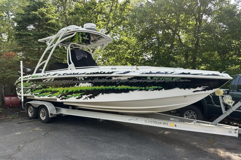The Image of 2015 Glasstream 280 Pro-XS boat on trailer with vibrant green and black graphics. - 0