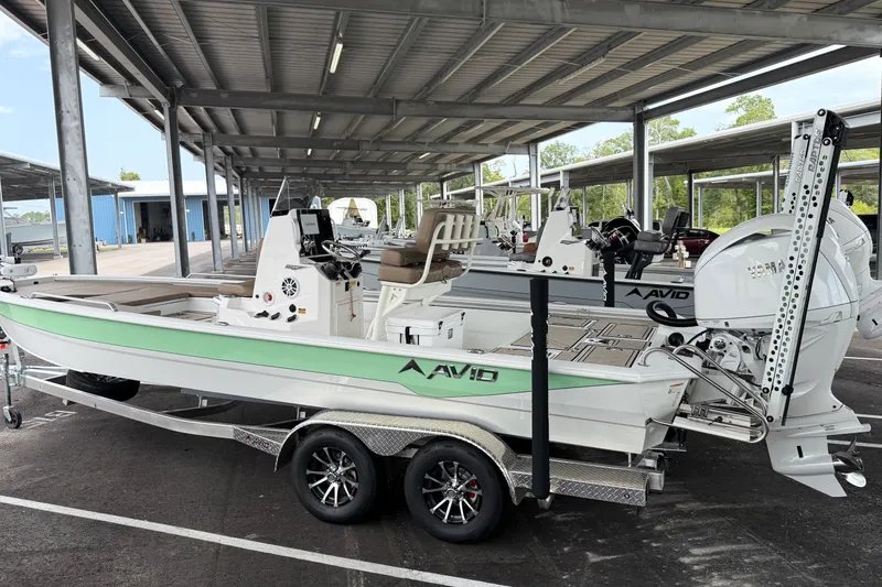 Slide: The Image of Avid 23 Fusion 2027 boat on trailer under covered parking, featuring sleek design and modern equipment. - 2