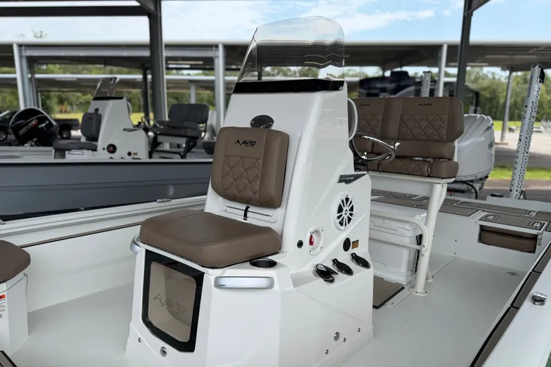 Slide: The Image of 2027 Avid 23 Fusion boat interior with brown seating and modern controls. - 19