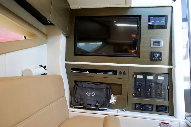 Slide: The Image of Interior of 2020 Cobalt A36 boat featuring a TV, control panels, and beige seating. - 20