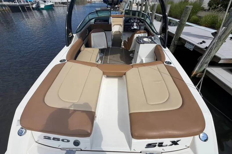 Slide: The Image of 2014 Sea Ray SLX 250 boat with spacious seating, docked by the water. - 28