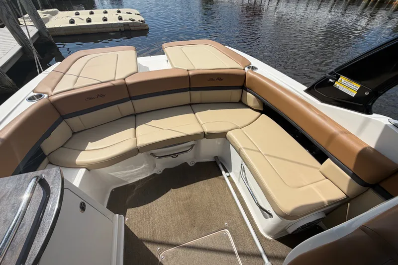 Slide: The Image of 2014 Sea Ray SLX 250 boat interior with tan seating, docked by the water. - 23