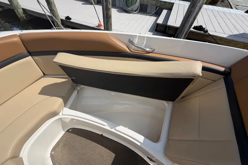 Slide: The Image of 2014 Sea Ray SLX 250 boat interior with tan seating and storage compartment. - 9