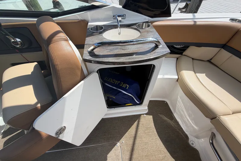 Slide: The Image of 2014 Sea Ray SLX 250 boat interior with seating, sink, and storage compartment. - 19
