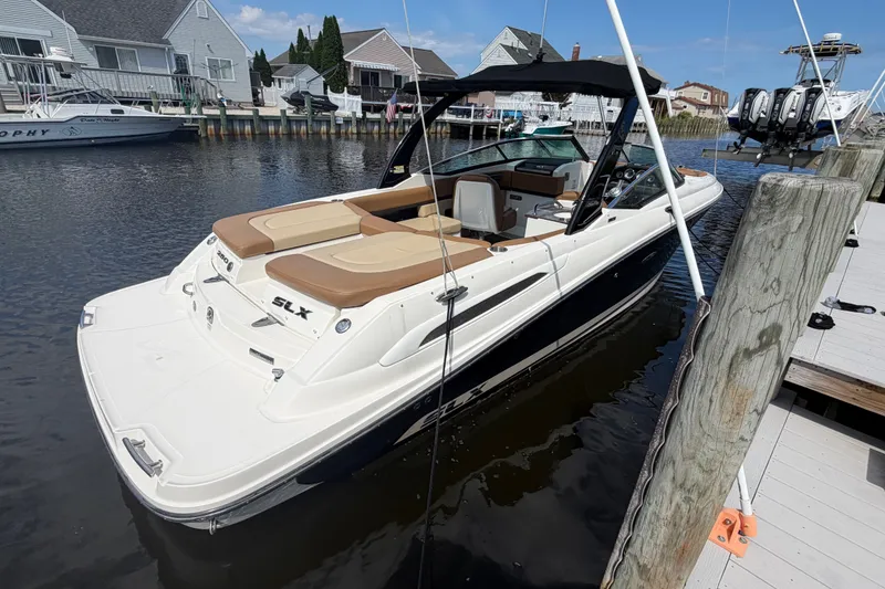 Slide: The Image of 2014 Sea Ray SLX 250 boat docked at a marina, featuring sleek design and comfortable seating. - 4