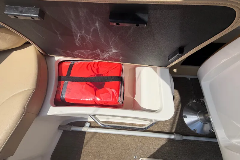 Slide: The Image of Storage compartment in a 2014 Sea Ray SLX 250 boat with a red safety kit. - 26