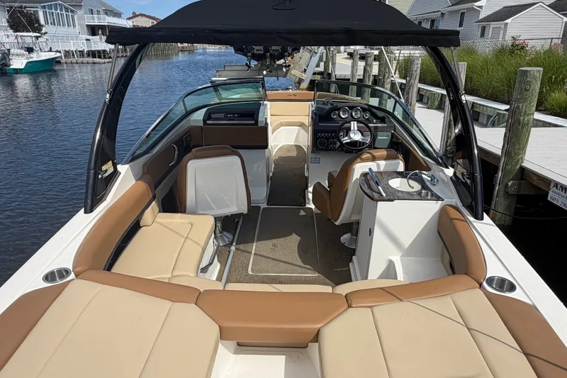 Slide: The Image of 2014 Sea Ray SLX 250 boat interior with tan seating and black canopy. - 29