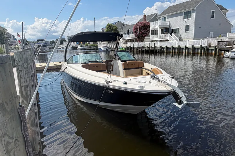 Slide: The Image of 2014 Sea Ray SLX 250 boat docked in a scenic waterfront neighborhood. - 1