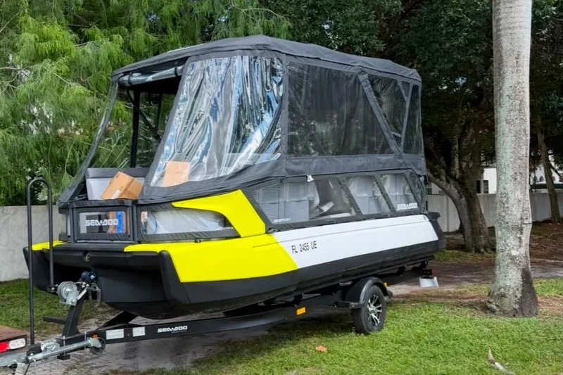 Slide: The Image of 2023 Sea-Doo Switch Cruise 21 on trailer, covered with protective canopy, parked outdoors. - 0