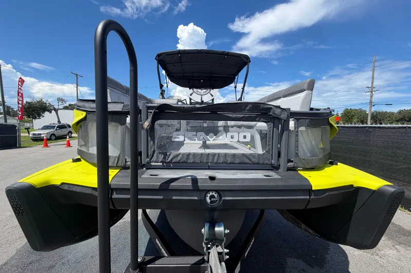 Slide: The Image of 2023 Sea-Doo Switch Cruise 21 pontoon boat, rear view, parked outdoors under blue sky. - 10
