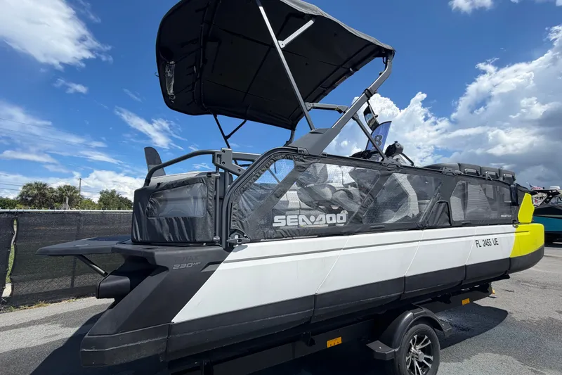 Slide: The Image of 2023 Sea-Doo Switch Cruise 21 pontoon boat with canopy, parked on trailer. - 2