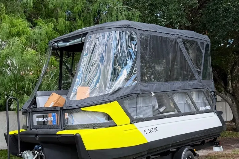 Slide: The Image of 2023 Sea-Doo Switch Cruise 21 with canopy, parked on trailer, surrounded by trees. - 1