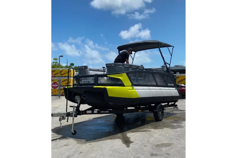 Slide: The Image of 2023 Sea-Doo Switch Cruise 21 pontoon boat on trailer under blue sky. - 3