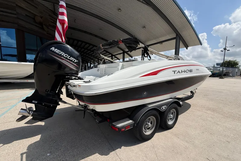Slide: The Image of 2017 Tahoe 1950 boat with Mercury engine on trailer, parked outdoors. - 2