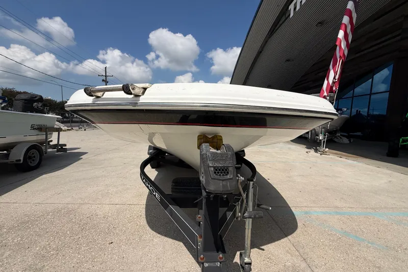 Slide: The Image of 2017 Tahoe 1950 boat on trailer, parked outdoors under a clear blue sky. - 6