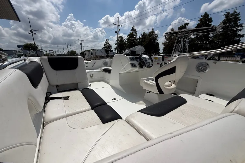 Slide: The Image of Interior of a 2017 Tahoe 1950 boat with white and black seating under a cloudy sky. - 13